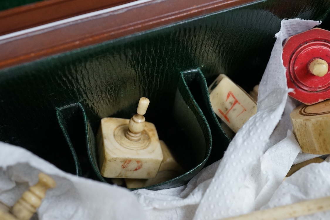 A collection of 19th century bone or coquille nut teetotum gaming spinners or twirlers and gaming items, in a leather box
